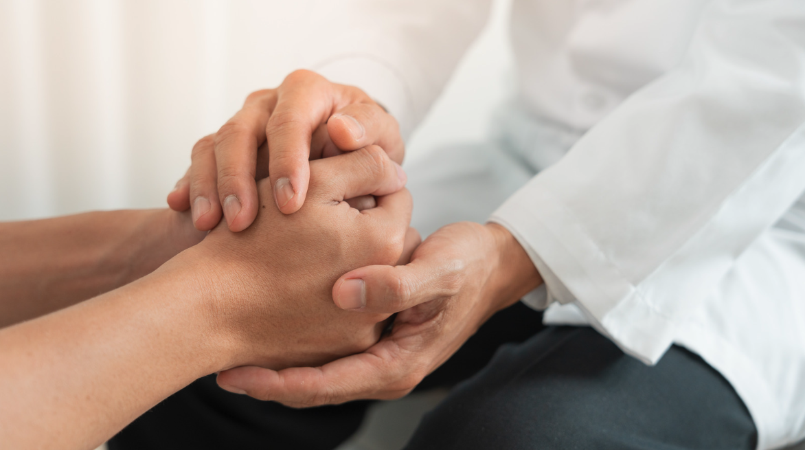 doctor holding patients hand